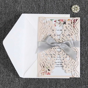 Pink laser cut wedding invitation set with floral inner sheet, ribbon and white envelope