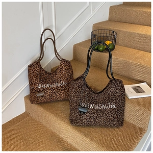 Detail of leopard print tote bags in two colors with stylish calligraphy design