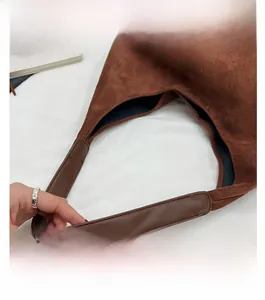 Detail view of the brown suede tote bag handle made with smooth matching leather grip