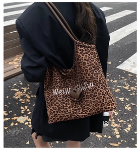 Street view of leopard print tote bag featuring drawstring closure and brown straps