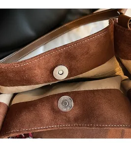 Close-up of magnetic buckle closure on large brown suede tote bag with fine stitching