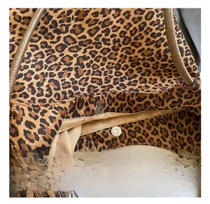 Detail shot of silver magnetic snap closure on a leopard print canvas tote bag