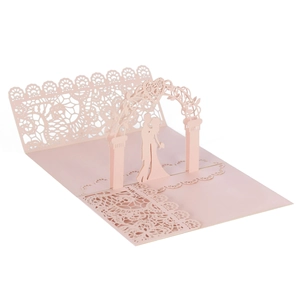 Detail of pink laser cut 3D wedding card with lace silhouette of couple under arch