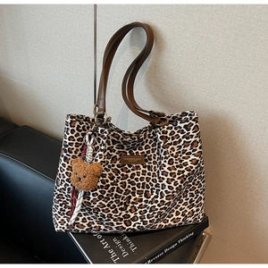 Dettaglio della borsa leopardata con manici marroni e ciondolo orsetto di peluche
