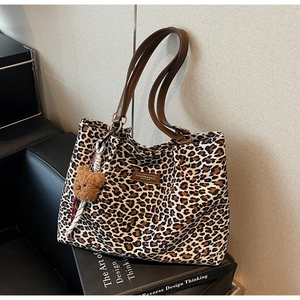 Dettaglio della borsa leopardata con etichetta in pelle e ciondolo a forma di orsetto bruno