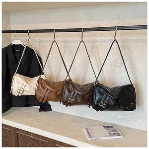Quatre sacs cabas en cuir plissé en crème, havane, marron et noir sur une barre d'exposition