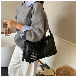 Détail du sac cabas en cuir noir avec boucles métalliques et finitions rétro chic