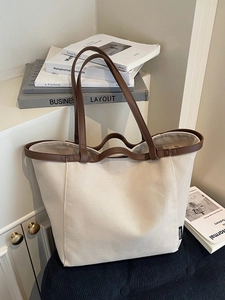 Minimalist cream canvas tote bag with brown leather straps and large capacity for women