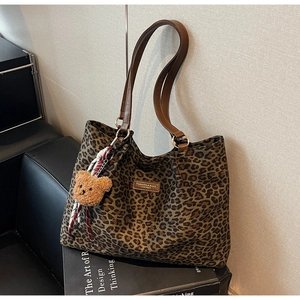 Dettaglio della borsa tote in pelle scamosciata leopardata con cinturini in pelle