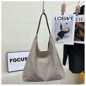 Detail of hobo shoulder bag in beige suede texture with dark leather straps