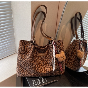 Dettaglio della borsa tote leopardata con etichetta in pelle e ciondolo a orsetto