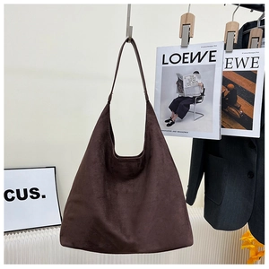 Detailed close-up of dark brown suede tote bag texture with long shoulder straps