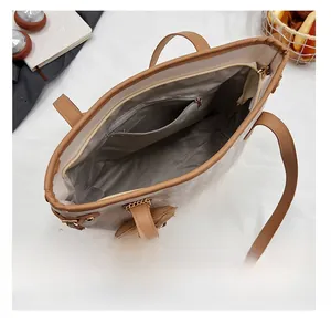 Top view of the spacious interior with a zipper pocket and brown leather handles