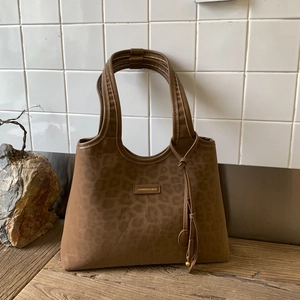 Close-up of brown leopard print tote bag with matte texture and gold metal fashion logo