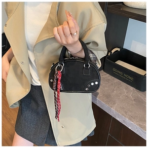 Detail of black suede Boston bag with silver studs and multi-color tassel charm