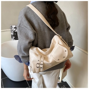 Détails du sac fourre-tout crème avec boucles argentées, rivets et poche latérale