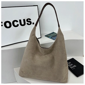 Detail view of large brown faux suede hobo bag with dark leather shoulder straps