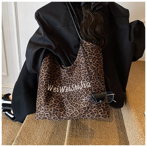 Close-up of leopard print canvas tote with letter embroidery and leather eyewear case