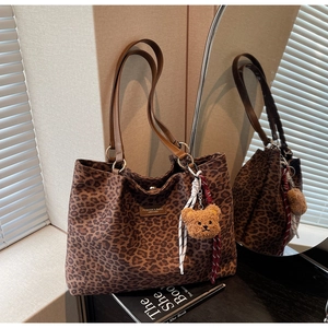 Dettaglio borsa tote leopardata in pelle scamosciata con manici in pelle e orsetto