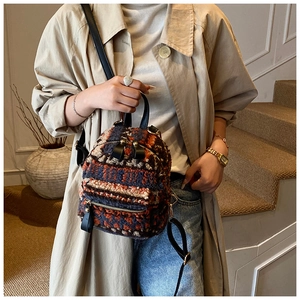 Detaillierte Nahaufnahme des bunten Plüsch-Rucksacks mit Goldzipper und Lederriemen