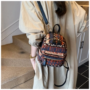 Nahaufnahme eines Retro-Plüsch-Minirucksacks mit Farblock-Strickmuster und Lederriemen