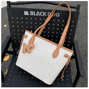 Detail of white woven tote bag texture with brown leather straps and puppy charm