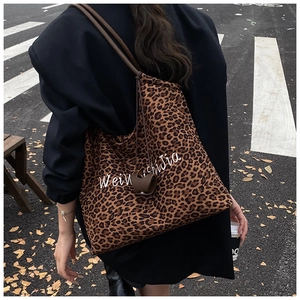 Street style view of large leopard print canvas tote bag with embroidery and leather straps