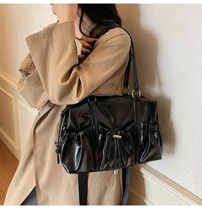 Détail du sac cabas en cuir noir avec plis froncés et large bandoulière