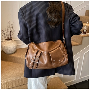 Gros plan d'un sac bandoulière vintage en similicuir marron avec boucles en métal