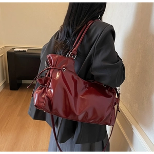 Détail du sac cabas bordeaux en cuir verni avec cordon et longues bandoulières
