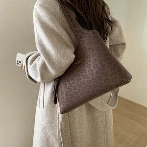 Close-up of leopard print tote bag texture and Fashion & Bag metal logo detail