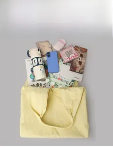 Top view of spacious yellow canvas tote bag filled with daily essentials and water bottle
