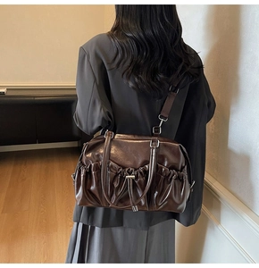 Mannequin portant un grand sac cabas marron foncé avec cordon et texture cuir brillant