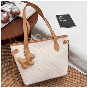 Detail of white checkered tote bag with khaki straps and a cute brown dog leather charm