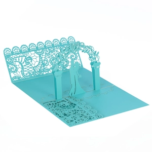 Detail of 3D pop-up wedding invitation featuring laser-cut floral arch and couple in light blue