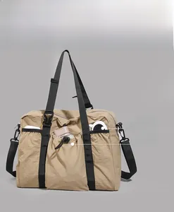 Detail view of the khaki travel bag showing multiple front utility pockets and nylon straps