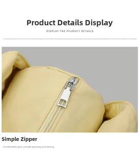 Macro view of silver rectangular metal zipper pull on light yellow fabric shoulder bag