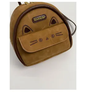 Close-up of brown suede mini cat backpack with embroidered details and metallic zipper