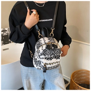Detail eines Mini-Plüschrucksacks mit schwarz-weißem geometrischem Muster und Lederriemen