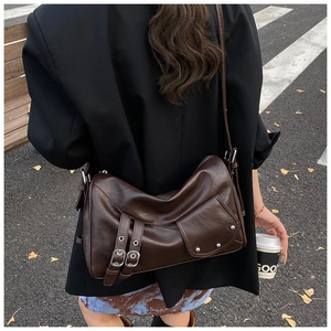 Vue détaillée du sac cabas en cuir marron foncé avec boucles argentées sur un mannequin