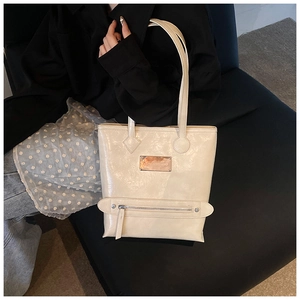 Détail du grand sac cabas blanc crème brillant avec plaque et fermeture éclair