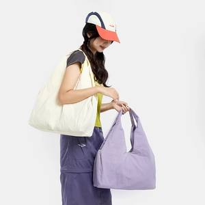 Close-up of off-white and light purple large capacity nylon tote bags with pleated texture