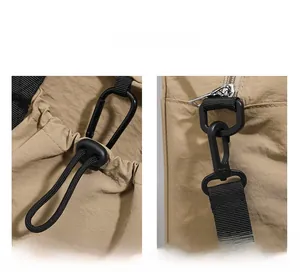 Detail view of khaki travel bag featuring a drawstring closure and detachable black metal hook