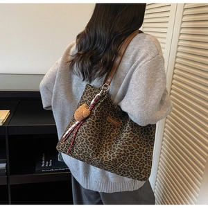 Dettaglio della borsa tote scamosciata leopardata con tracolle in pelle marrone e orsetto