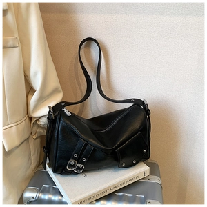 Détails du sac cabas vintage avec boucles argentées et rivets posé sur une valise