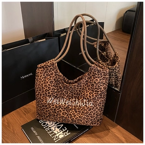 Detail of leopard print tote bag featuring WeiWeiShiJia lettering and brown handles