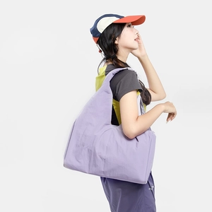 Close-up of light purple large capacity nylon tote bag shown on model for size and texture