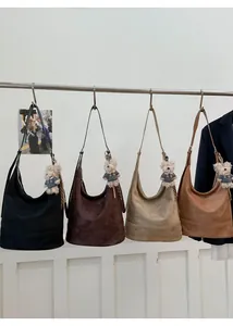 Detail shot of four suede bucket bags in different colors with cute bear charms