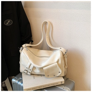 Détail du sac fourre-tout blanc crème avec clous en argent sur une valise