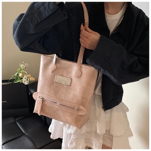 Détail du cabas rose montrant la texture plissée brillante et la poche zippée